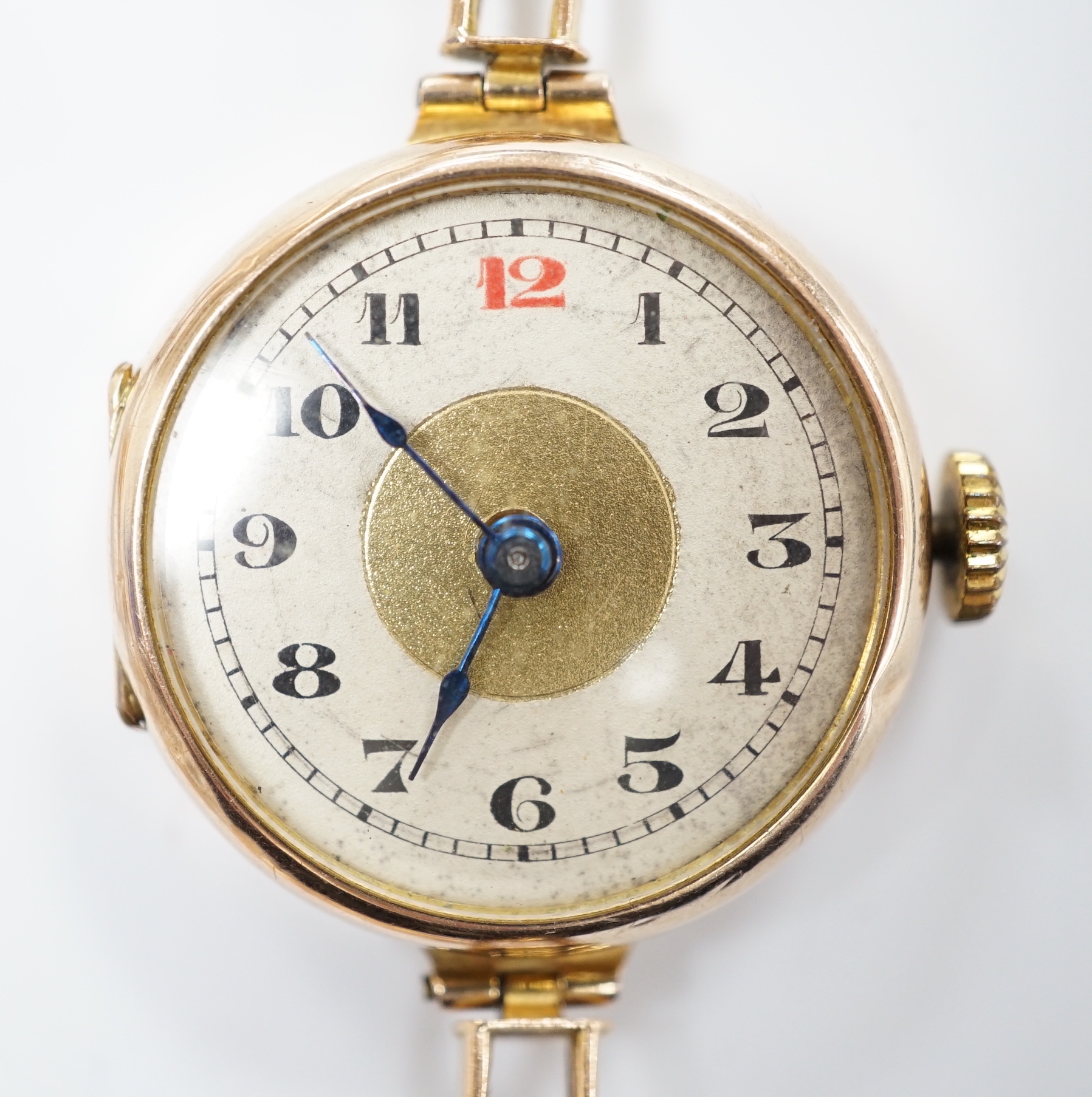 An early 20th century 9ct gold manual wind wrist watch, on a 9ct expanding bracelet, case diameter 25mm, gross weight 14.9 grams.